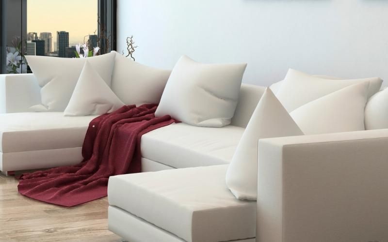 a white couch with a red blanket